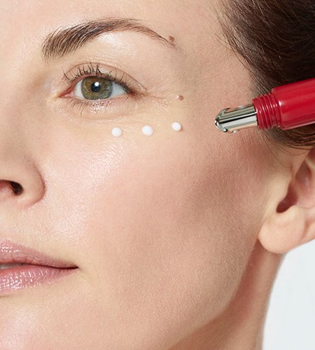 Brünette Frau traegt die Revitalift Laser X3 Anti Age Augencreme auf